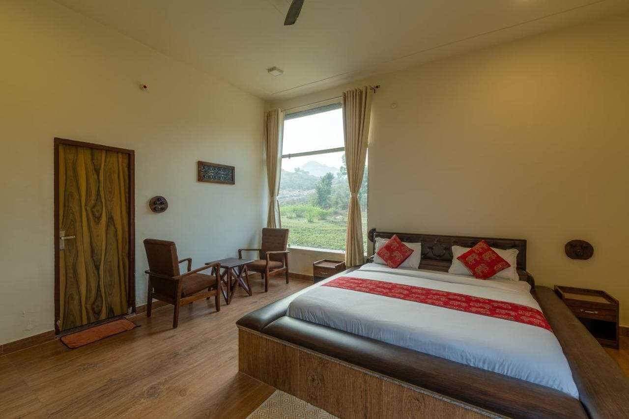 Deluxe room with a large bed, wooden floor and garden window