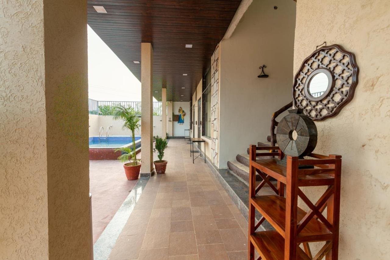 Shaded verandah with carved wooden decor beside the pool