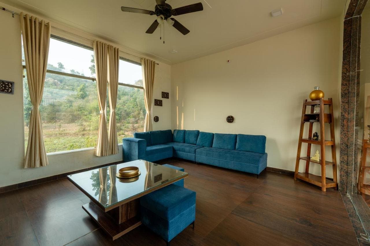 Villa lounge with blue sofas and big windows onto the hills